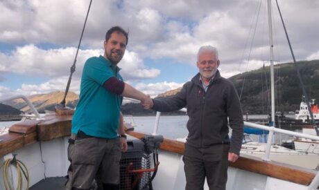 Iain and Ted shaking hands on the bow